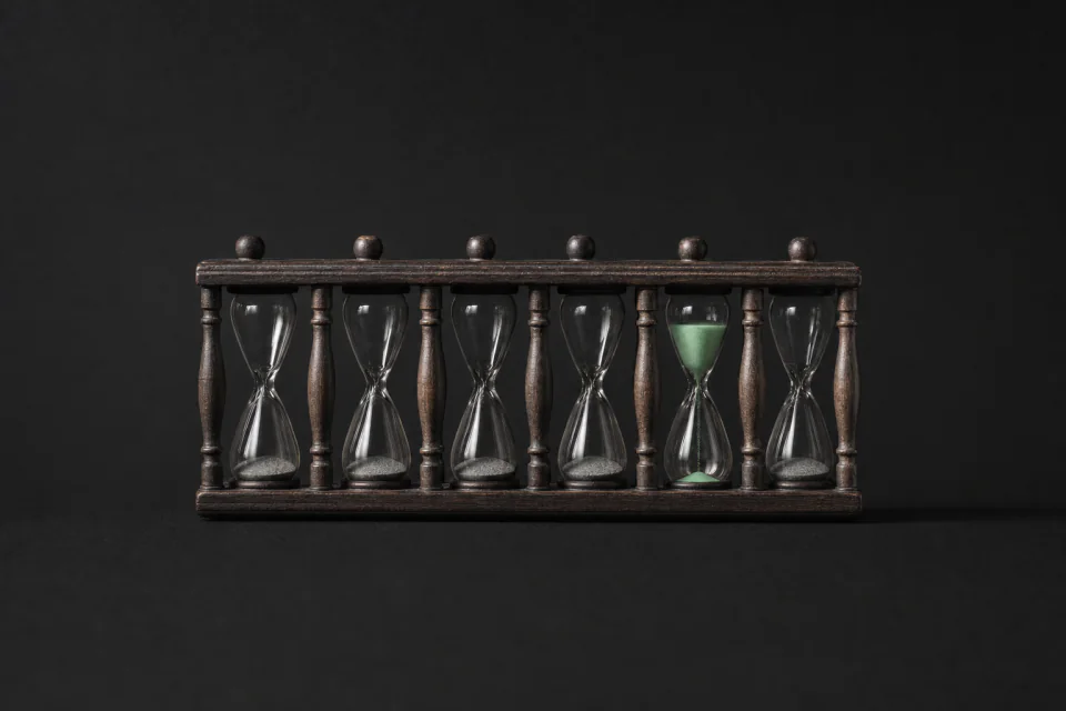 A rack of six hourglasses, five run out and one still draining