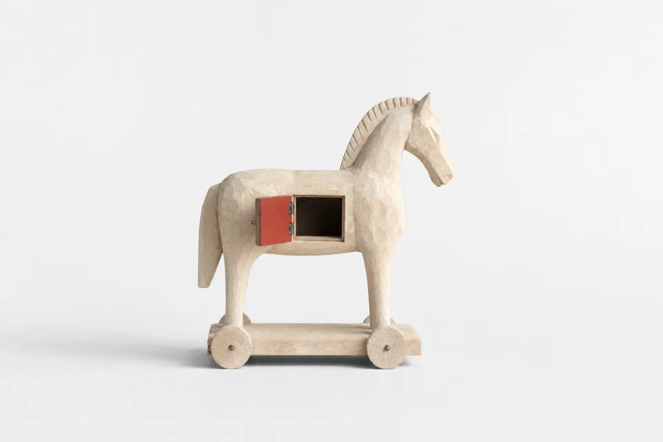 A carved wooden Trojan horse with a hatch in its belly swung open